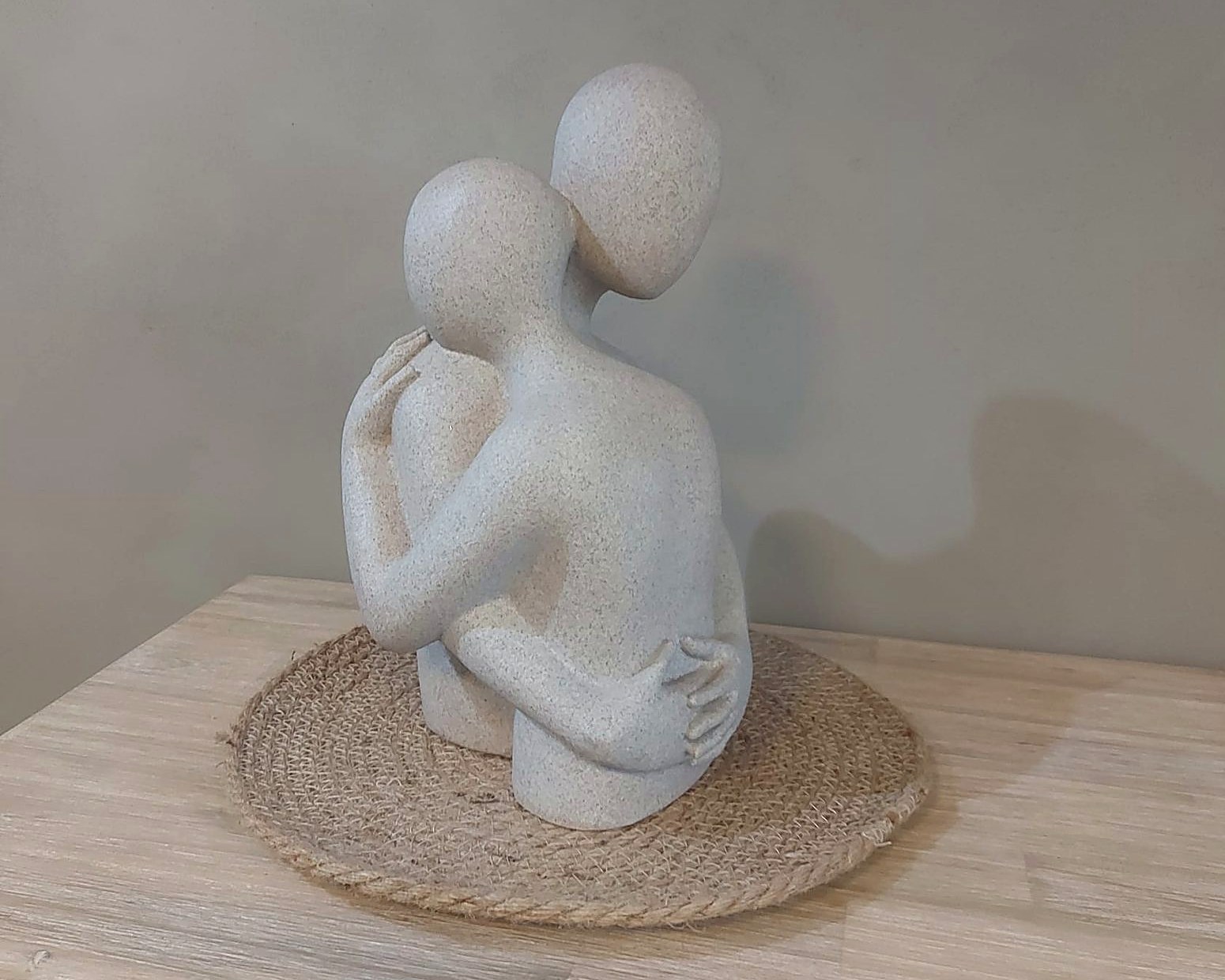 Beeldje van twee figuren die elkaar omarmen, symbool van troost
