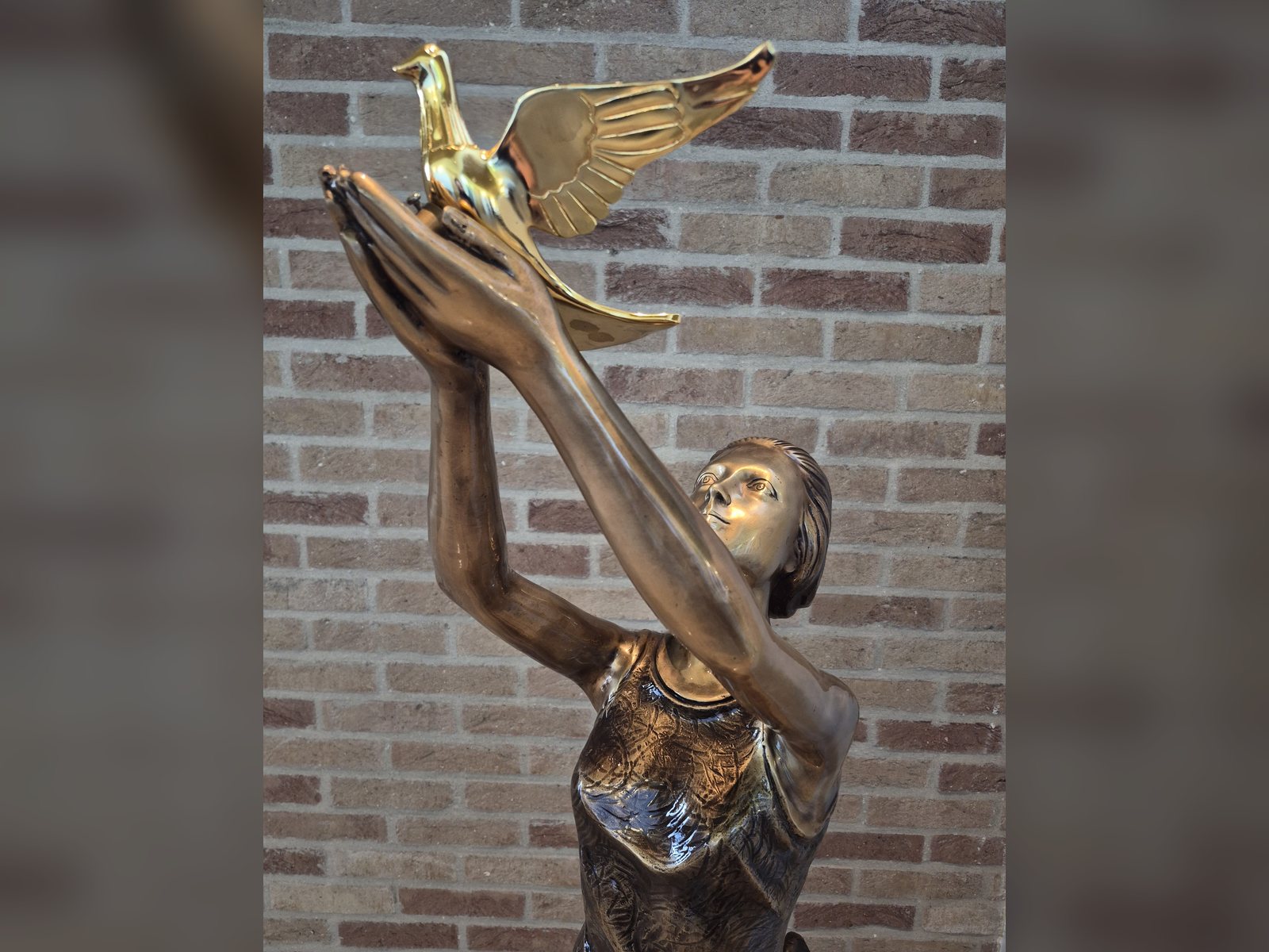 Bronzen beeld van een vrouw die een vogel loslaat, in het funerarium